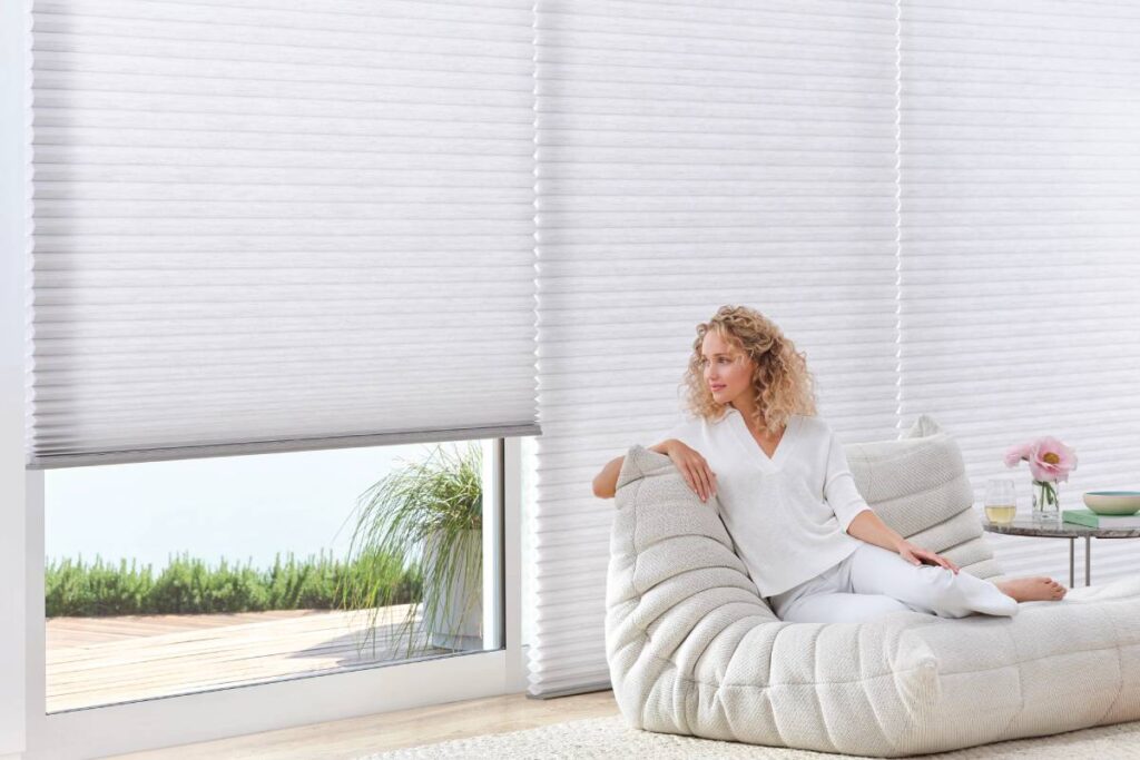 A woman enjoying Hunter Douglas Duette® Cellular Shades near Natick, Massachusetts (MA)