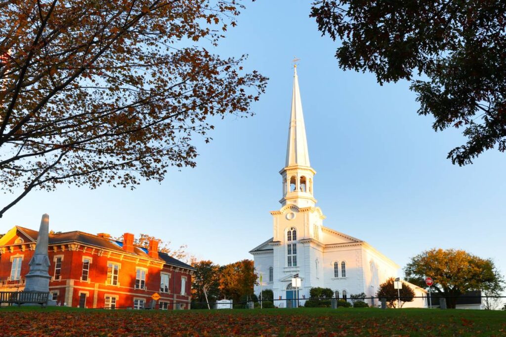 A scenic view of Southborough, MA, with historical buildings and fall leaves on the ground near Southborough, MA