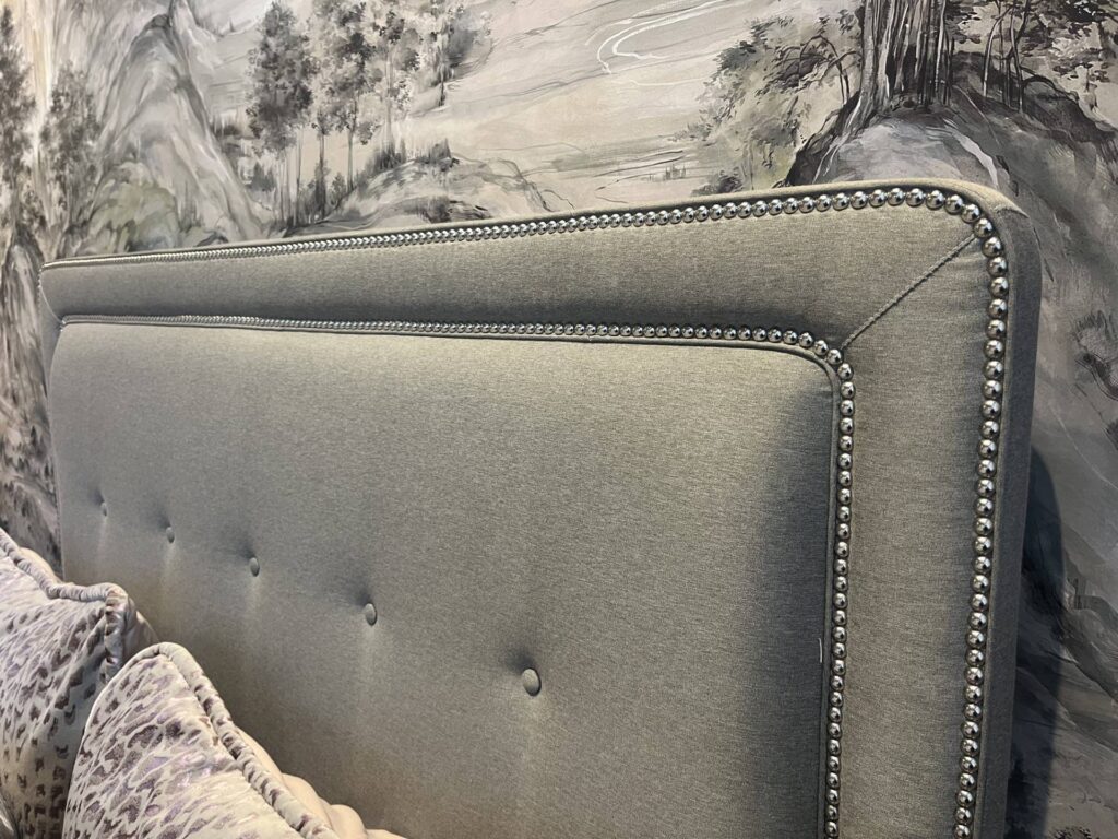 Upholstered headboard with toile wallpaper and matching gray pillows near Southborough, MA